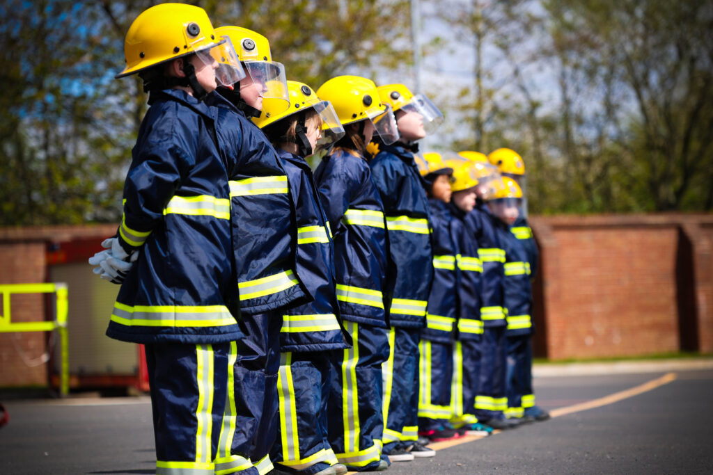 Children from Allanson St Primary School lining up in fire fighter uniforms