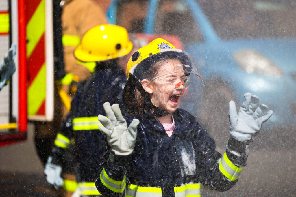 young girl screaming with water spraying around 