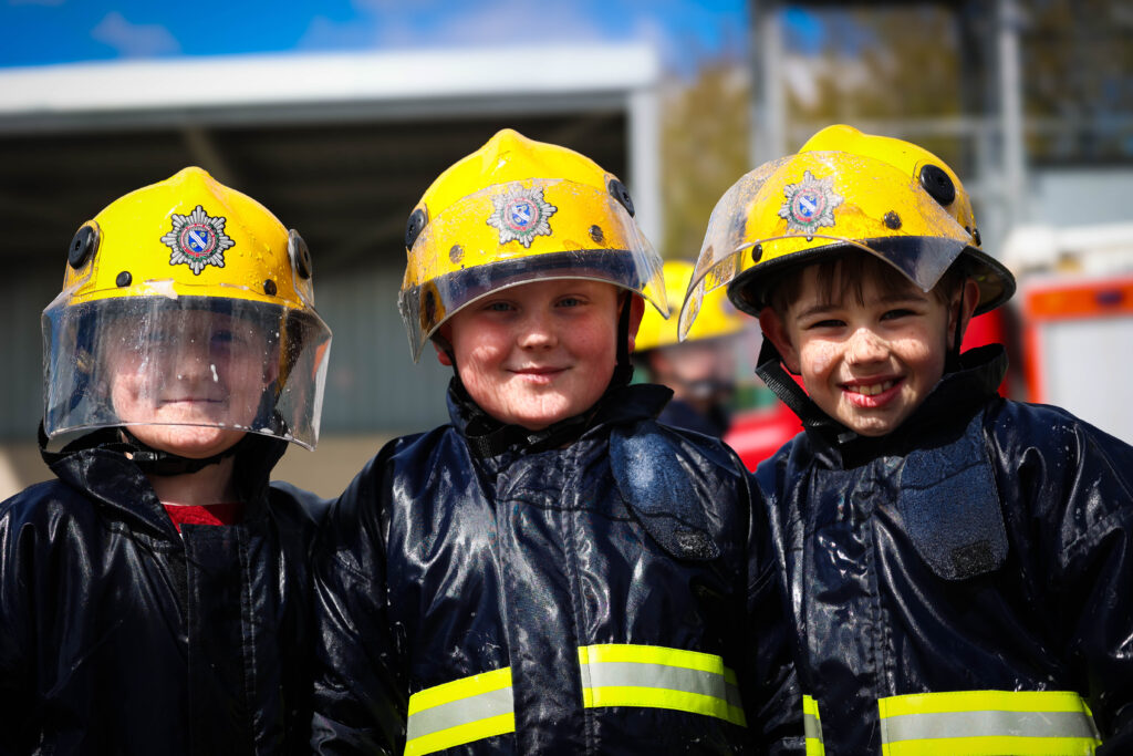 three young boys in fire uniform